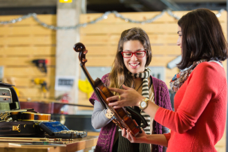a music retail store employee assists customer